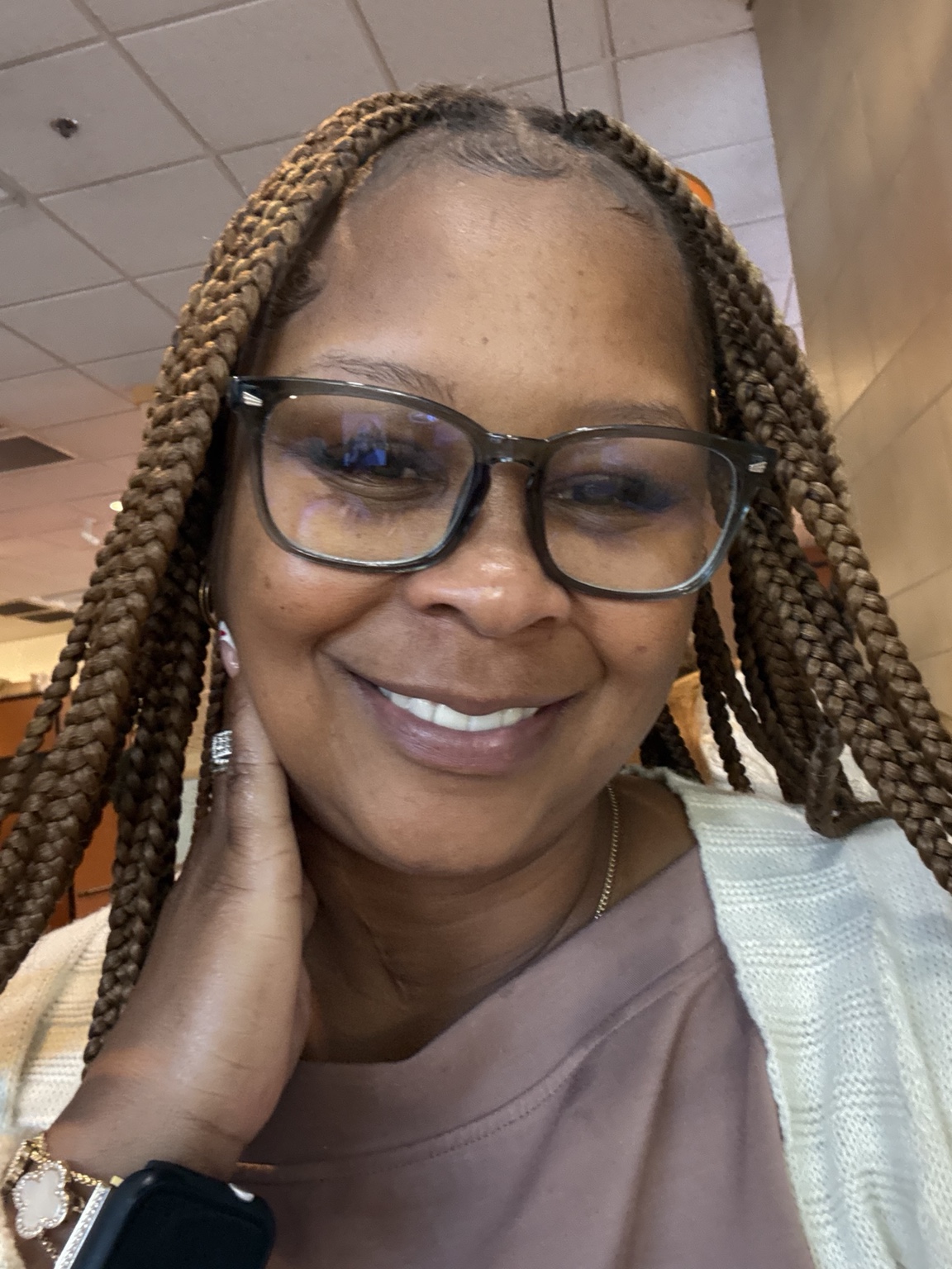 Khaliah Butler, founder of The Herbal Bonnie, smiling with braided hair and glasses